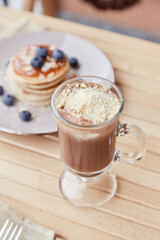 Dessert - belgian chocolate with ice cream in glass and traditional pancakes with syrup and blueberry outside. Delicious breakfast