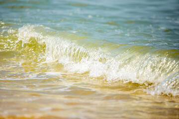 swash of the rolling wave on the white sand beach