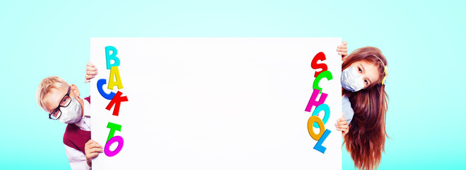 Young children with protection masks against corona virus at school.