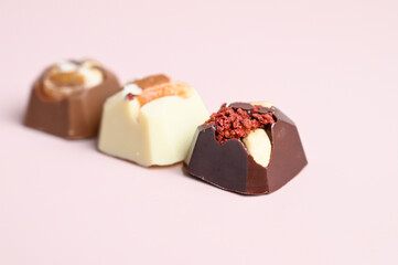 Set of handmade bonbons with berry fruit and nuts filling on pink background. Exclusive handcrafted...