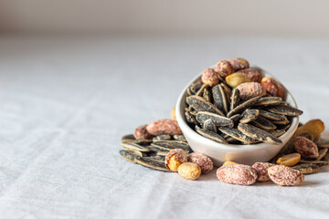 Roasted salted peanuts and roasted salted sunflower seeds. Close-up. Nuts. Eaten.
