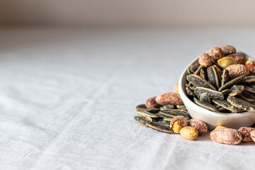 Roasted salted peanuts and roasted salted sunflower seeds. Close-up. Nuts. Eaten.