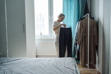 A young girl chooses what to wear in front of an open closet. . High quality photo