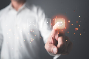 Customer satisfaction and service giving rating with happy icon. Businessman pointing a smiley face icon to assess satisfaction with product and services with highest level, positive feedback.