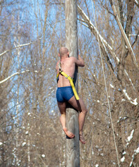 A man climbs a log in winter. Shrovetide, Slavic holiday