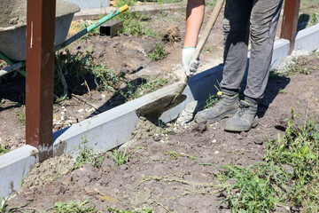 A worker is installing a concrete curb at a construction site.