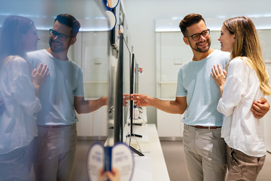 Portrait of happy couple shopping in a tech store. Technology people smart device concept - Powered by Adobe