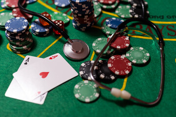 poker chips, money, stethoscope on blackjack table
