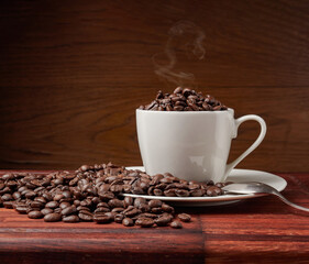 Coffee cup and coffee beans on a wooden background. View from above.