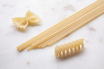 small composition of durum wheat pasta on white marble background