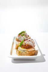 Aesthetic composition with tomato bruschetta on white background with harsh shadows. Italian bruschetta with tomatoes and cheese on fine dining in summer. Elegant menu concept.