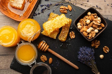 Honeycomb on slate tray with honey and nuts on kitchen table