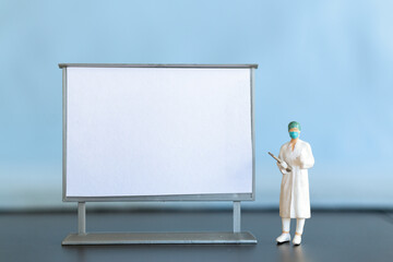 Miniature Doctor standing With Blank White Board
