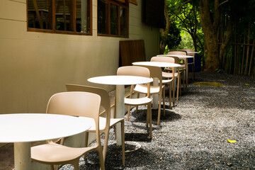 Modern white chairs and table in garden.
