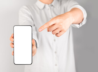 Woman forefinger pointing to phone mockup. Application advertisement. Female recommending mobile app, website, social networking site.