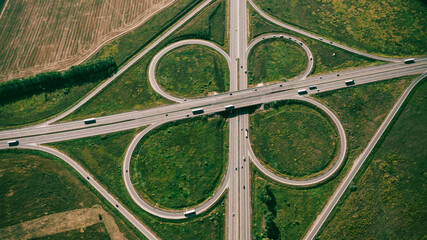 Clover or daisy, simple and cheap type of road junction. Aerial view of beautiful highway road...