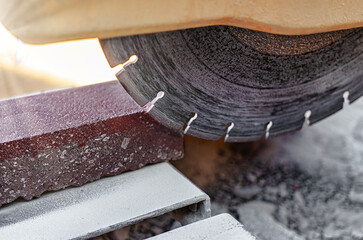 The circular diamond saw cuts concrete paving slabs. Concrete cutting machine close-up.