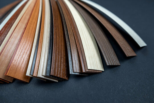 Samples of laminate and vinyl tiles on wooden background isolated.