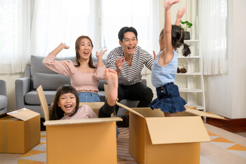 Fototapeta na wymiar Asian family husband and wife and children with cardboard boxes having fun on moving day, Mortgage, loan, property and insurance concept.