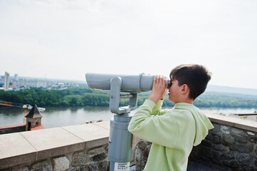 Obraz premium Boy looking at touristic telescope of Bratislava view, Slovakia.