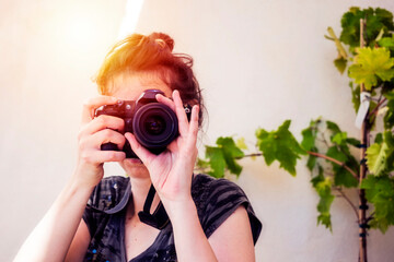 Woman taking picture outdoors with sunlight
