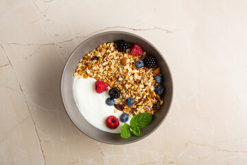 Overhead view of healthy grain granola with berry yoghurt top view on light surface