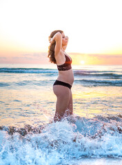 Fototapeta na wymiar Preciosa fotografía de una mujer embarazada durante el amanecer en la playa. 
