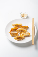 Close up of pan fried asian food gyoza and wooden chopsticks