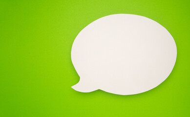 A blank white speech bubble over a light green background