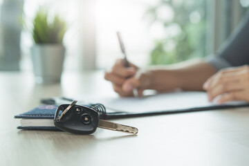 Car rental service concept. Close up view Hand of agent giving car key to customer after signed...
