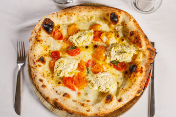 Pizza napoletana con mozzarella, pomodori rossi, pomodori gialli, ricotta e basilico fresco servita...