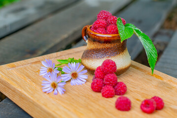 a lot of raspberries in a brown vase. High quality photo
