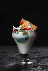 ice cream and fruits on black background. healthy breakfast. copy space.