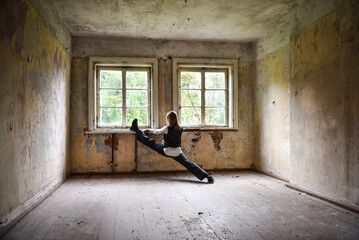 Girl doing twine in the old room of an abandoned house