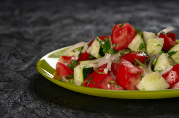 close-up shot of salad with tomatoes and cucumbers on black