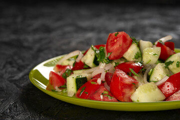 close-up shot of salad with tomatoes and cucumbers on black