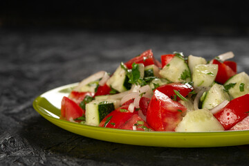 close-up shot of salad with tomatoes and cucumbers on black