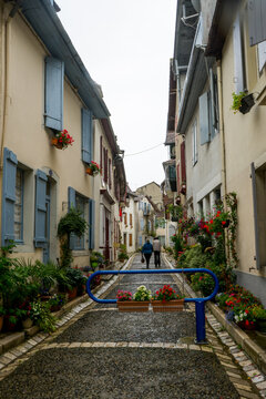 Un couple marche dans les rues piétonnes fleuries de la cité béarnaise salies de Béarn