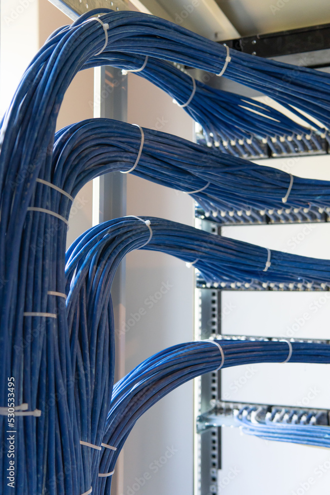 Poster a large group of utp cables, rack ethernet cables, patch panel utp cables in a server rack in a data