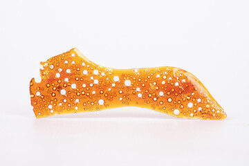 golden textured cannabis wax close up macro on white background