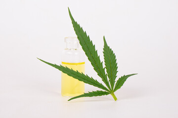 hemp medicinal oil and green leaf on white background
