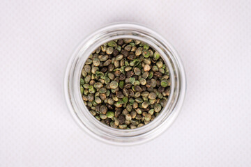 cannabis seeds in glass jar closeup, hemp natural grain.