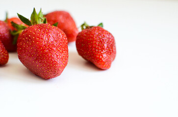 Three strawberries with strawberry leaf on white background.