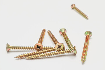 A bunch of yellow screws on a white background. yellow construction screws on white, side view, place for text, copy space.
