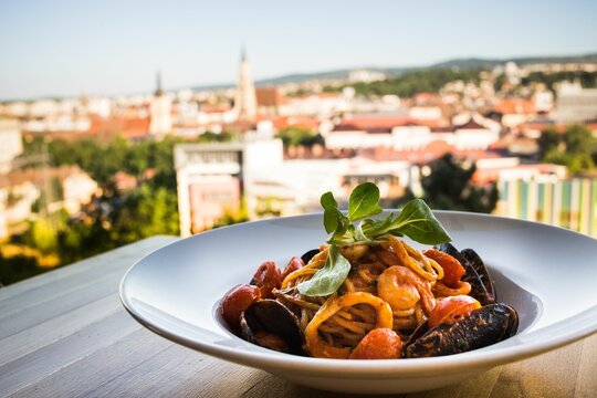 Beautiful shot of spaghetti allo scoglio in a white plate in Rose Garden Bern