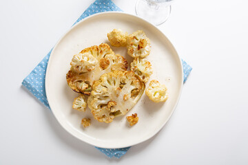 Vegetarian roasted cauliflower steak on white plate