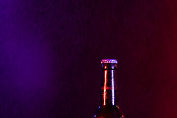 Image of brown glass lager beer bottle with crown cap, with copy space on smokey background