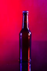 Gordijnen Image of brown glass lager beer bottle with crown cap, with copy space on red background © vectorfusionart