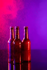 Foto op Canvas Image of three brown beer bottles with crown caps, with copy space on red and purple background © vectorfusionart
