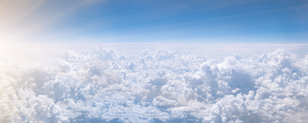 Banner with white cumulus cloud. Over clouds. Aerial view from airplane window.